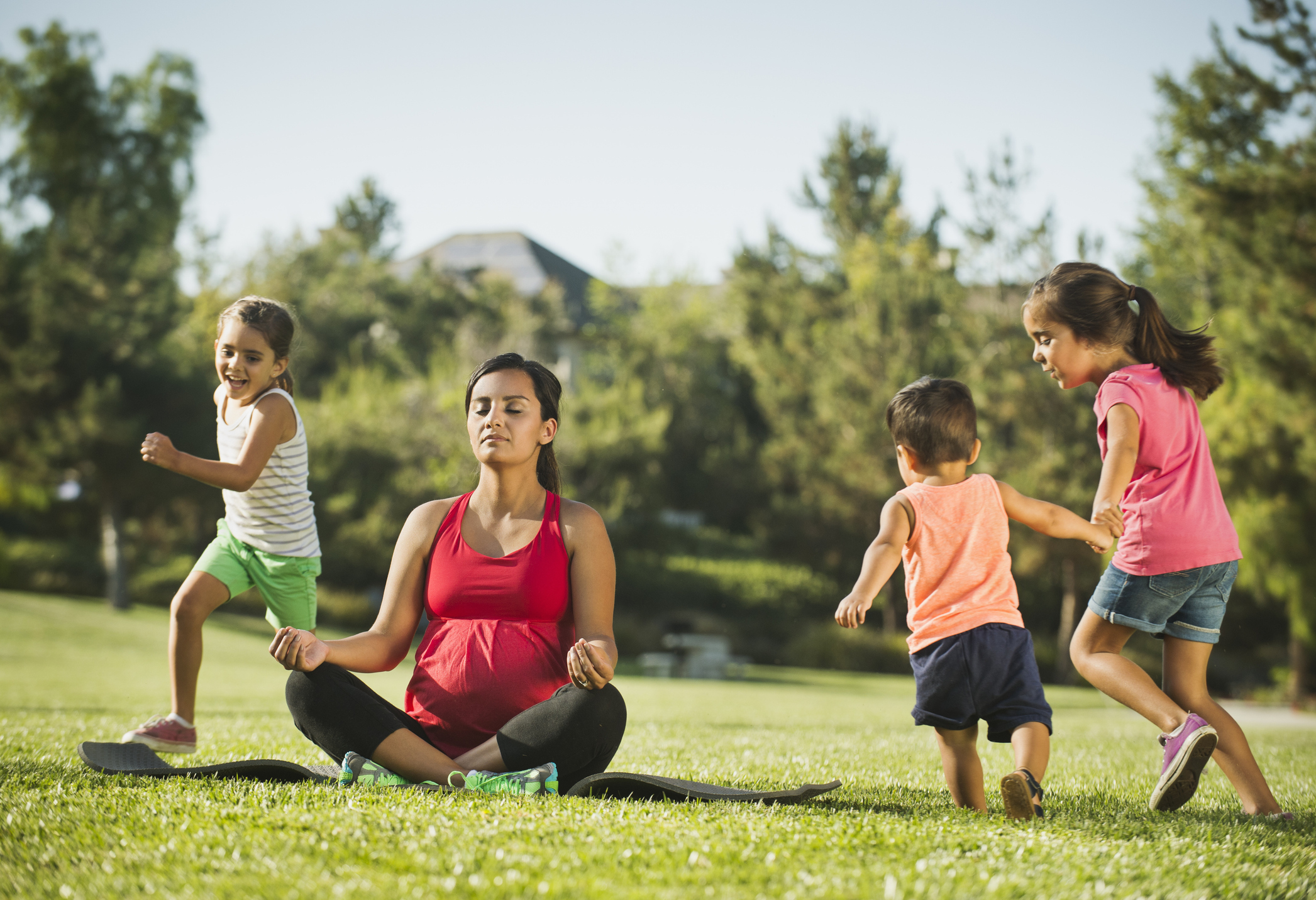 Mom with kids doing yoga at the park
